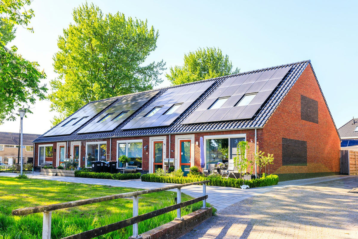 Moderne woning met zonnepanelen op het dak – sla je zonnestroom op in een thuisbatterij